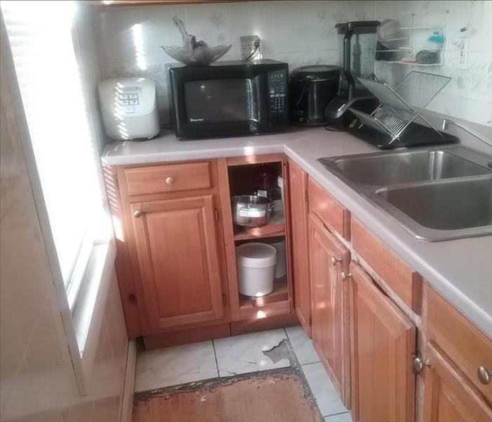 Kitchen with damaged floor and mold due 