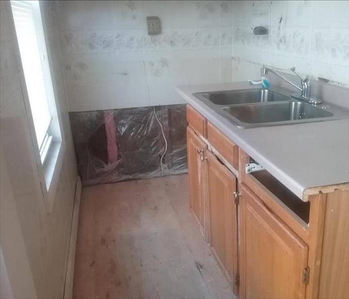 Kitchen with damaged floor & cabinets removed, no mold