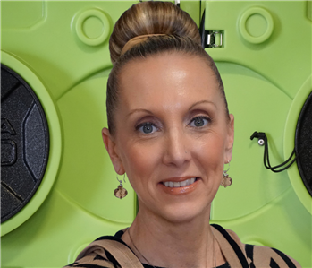 Smiling woman with top knot blond hair. Standing in front of air drying equipment